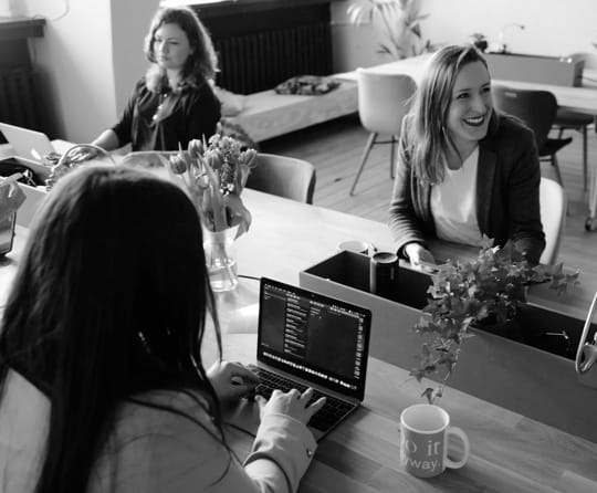 Image of some people working on laptops while sitting in a office